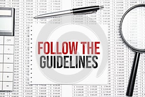 FOLLOW THE GUIDELINES text on paper with calculator,magnifier ,pen on the graph background