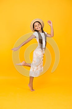 Follow her dream. full of happiness. summer kid fashion. little girl jumping high on yellow backdrop. energetic kid on
