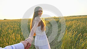 Follow me. Happy couple holding hands, running on golden wheat field and having fun outdoors, Couple walking on meadow