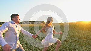 Follow me. Happy couple holding hands, running on golden wheat field and having fun outdoors, Couple walking on meadow