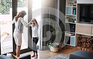 Follow my lead. Full length shot of an attractive young woman and her daughter dancing while spending time together at