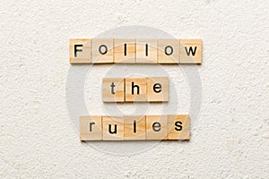 Follow The Rules word written on wood block. Follow The Rules text on table, concept