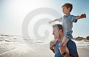 Follow the sun and youll find the fun. a father carrying his little son on his shoulders at the beach.