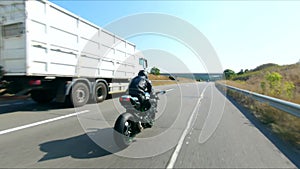 Follow to motorcyclist riding on modern sport motorbike at highway. Biker racing his motorcycle on country road. Guy