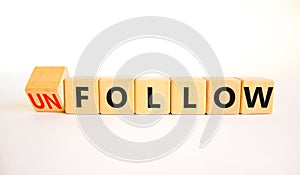 Follow or unfollow symbol. Turned wooden cubes and changed concept words Follow to Unfollow. Beautiful white table white