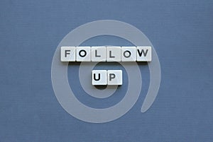 ' Follow Up ' word made of square letter word on grey background photo