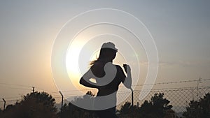 Following to sporty girl jogging in country road at sunrise. Young woman running outdoors at morning. Healthy active