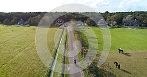 Following Young Couple Riding A Tandem Bike - Ameland, The Netherlands, 4K Drone Footage