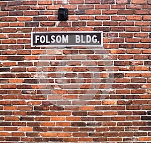 Folson BLDG Red Brick Wall with Black and White Sign