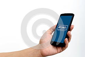 FOMO, fear of missing out concept. Male hand holding smartphone