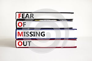 FOMO fear of missing out symbol. Concept words FOMO fear of missing out on books on a beautiful white background. Copy space.