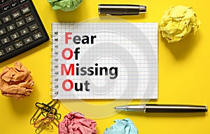 FOMO fear of missing out symbol. Concept words FOMO fear of missing out on white note on a beautiful yellow background. Black