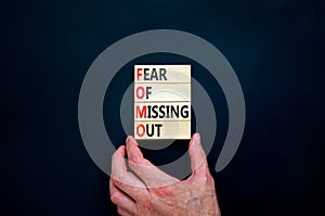 FOMO fear of missing out symbol. Concept words FOMO fear of missing out on wooden blocks on a beautiful black background.