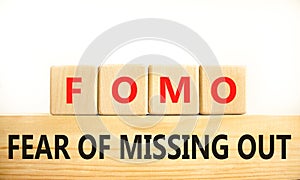 FOMO fear of missing out symbol. Concept words FOMO fear of missing out on wooden blocks on a beautiful white background. Business