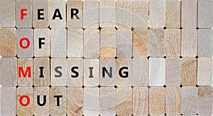 FOMO fear of missing out symbol. Concept words FOMO fear of missing out on wooden blocks on beautiful wooden background. Business