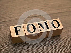 FOMO fear of missing out, text words typography written with wooden letter, life and business motivational inspirational