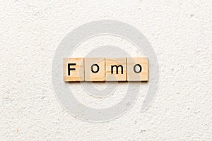 fomo word written on wood block. fomo text on table, concept