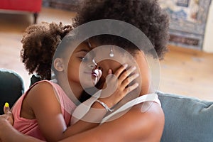 Fond African American mother and daughter hugging