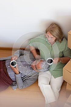Fond elderly couple relaxing while moving into new house
