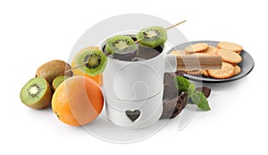 Fondue pot with chocolate and fruits on background