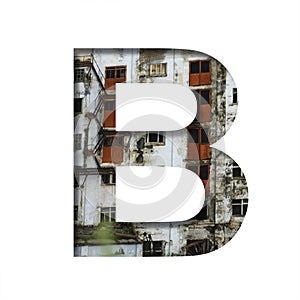 Font on an abandoned industrial building. The letter B cut out of paper on a background of windows and doors of an abandoned