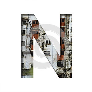Font on an abandoned industrial building. The letter N cut out of paper on a background of windows and doors of an abandoned