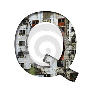 Font on an abandoned industrial building. The letter Q cut out of paper on a background of windows and doors of an abandoned