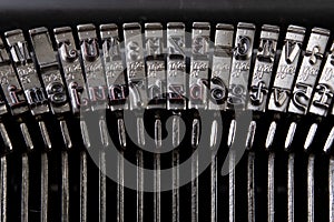 Font in a typewriter. Metal stamps for imprinting letters on a white sheet