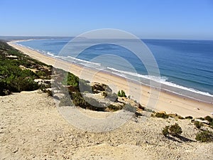Fonte da Telha Beach in Costa da Caparica coast, with the Espichel Cape seen at the Atlantic Ocean horizon. photo