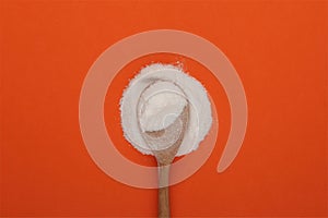 Food additive E363. Succinic acid powder in wooden spoon, close-up. Butanedioic acid or spirit of amber