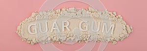 Food additive E412, banner, design element. Guar gum powder or guaran on pink background. Inscription GUAR GUM