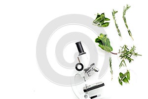 Food analysis. Pesticides free vegetables. Herbs rosemary, mint near microscope on white background top view copy space