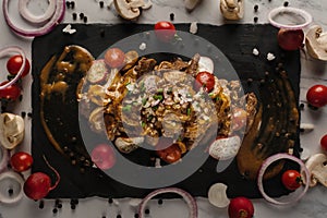 Food background of beef stroganoff served on black slate stone plate, selective focused