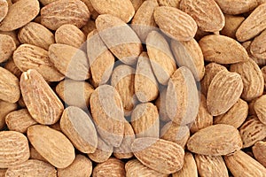 Food background - big shelled roasted salted almonds situated arbitrarily