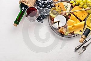 Food background with cheese. Blocks of moldy cheese, grapes, honey, nuts over on white background.