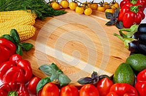 Food background with copy space for text. Fresh organic vegetables and herbs on the wooden table: bell pepper, corncobs, avocado