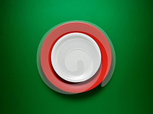 Food background. Empty ceramic white plate over a red plate on green background