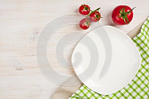 Food background with empty plate, tomatos and kitchen towel