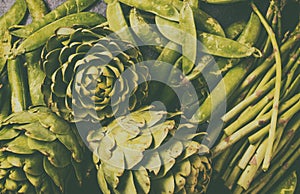 Food background with fresh green vegetables - asparagus, artichoke and green pea. Toned photo