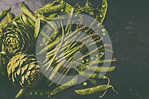 Food background with fresh green vegetables - asparagus, artichoke and green pea. Toned photo