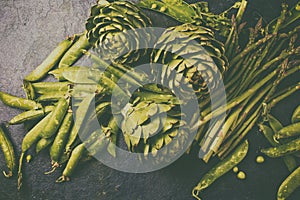 Food background with fresh green vegetables - asparagus, artichoke and green pea. Toned photo