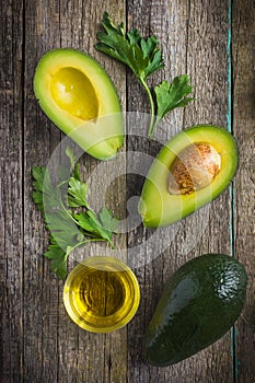 food background with fresh organic avocado, lime, parsley and olive oil