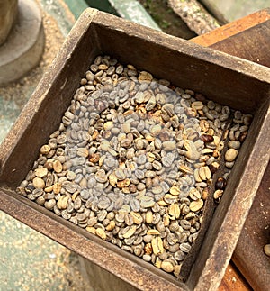 Food background with Green unroasted coffee beans in old wooden box. Top view