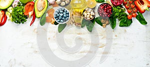 Food background. Healthy food for humans: vegetables, fruits, fish, meat, nuts and greens. on a white wooden background.