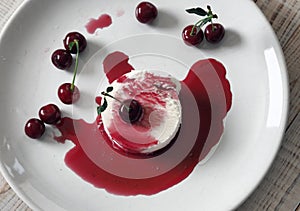 Food background.Ice cream with cherries on a white plate, poured with red jam.Top view.