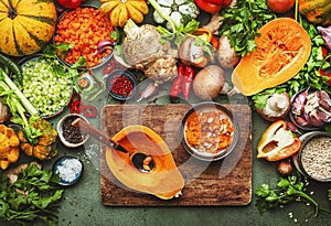 Food background. Peeled pumpkin and spoon on cutting board. Vegetables, mushrooms, roots, spices - ingredients for vegan, cooking