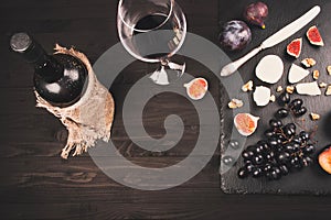 Food background with red wine, figs, grapes and cheese