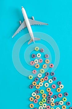 Food background of round colorful cereal and toy plane, breakfast concept.