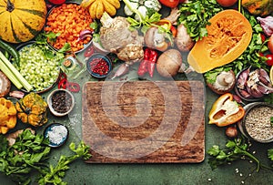 Food background. Rustic wooden cutting board. Vegetables, mushrooms, roots, spices - ingredients for vegan cooking. Healthy eating