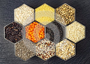 Food background of various cereals and grains in hexagonal shaped honeycomb jars
